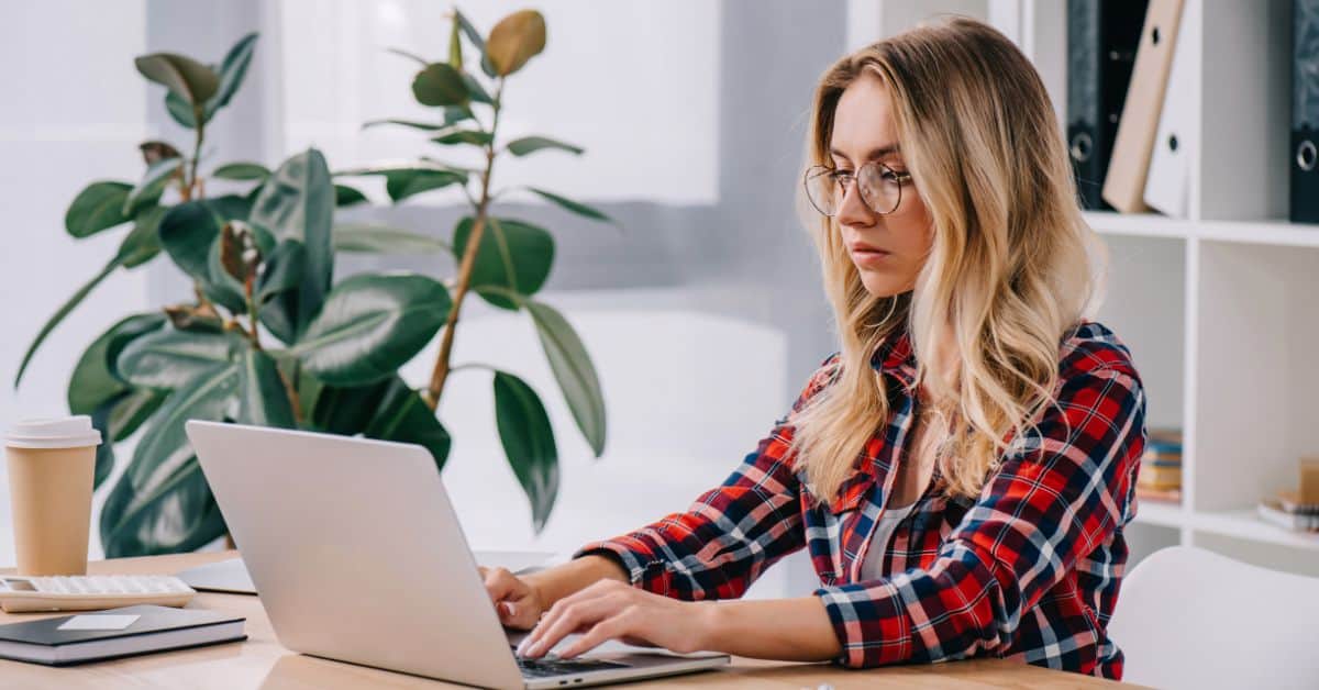 Focused business woman using laptop while taking part in webinar