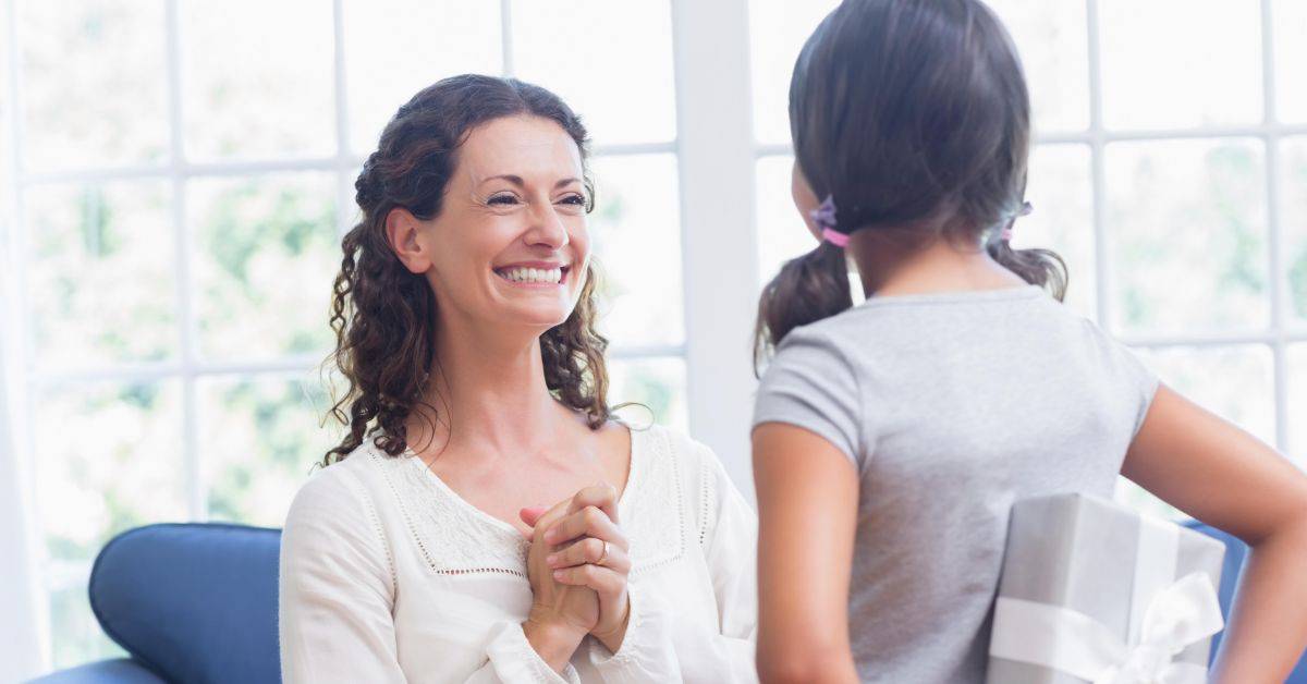 young girl giving a present to her mother for mothers day